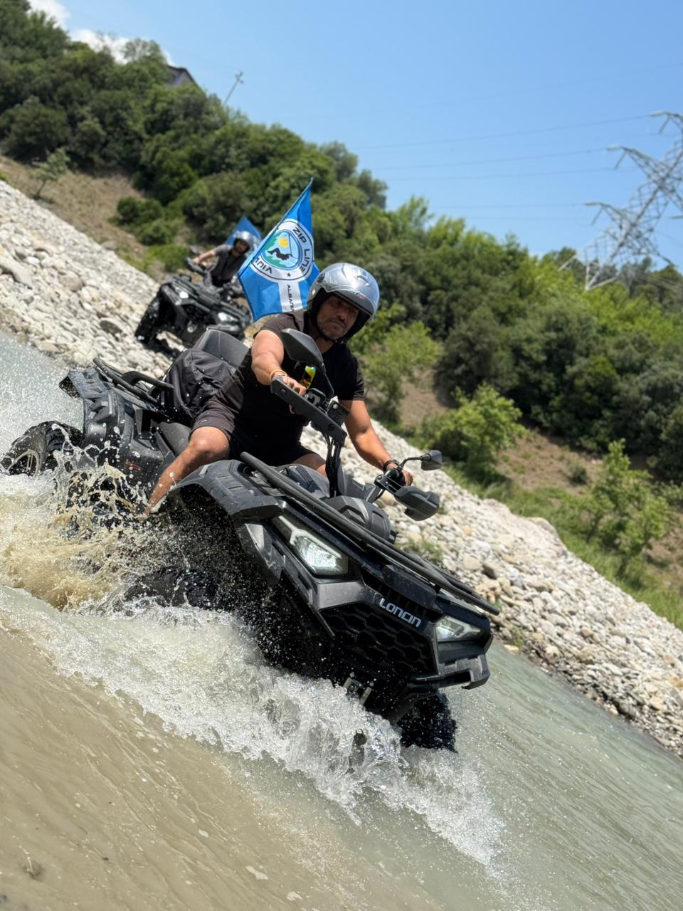 Red quad bike speeding through a forest trail near Tirana